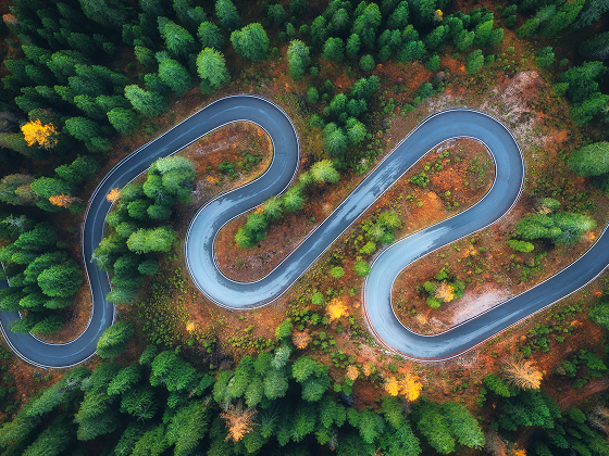 aerial-view-of-winding-road-in-colorful-autumn-for-2024-11-27-12-06-36-utc 1